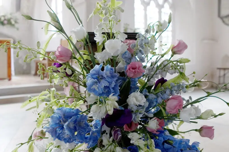 A blue and white flower arrangement in a church.
