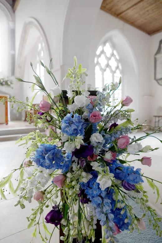 A blue and white flower arrangement in a church.