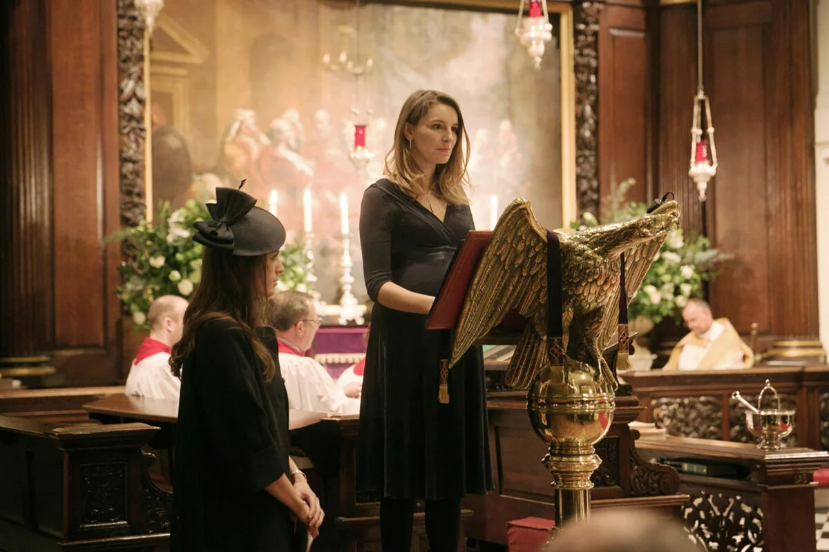 A woman standing at a podium in front of a statue of an eagle.
