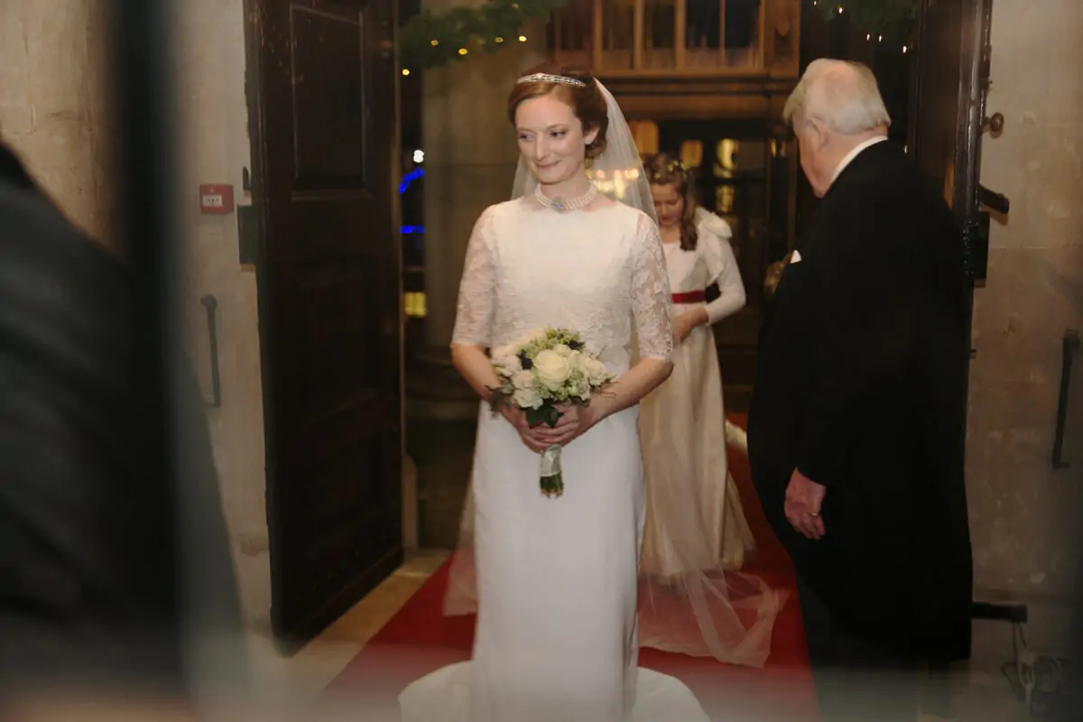 A bride in a wedding dress walking down the aisle.
