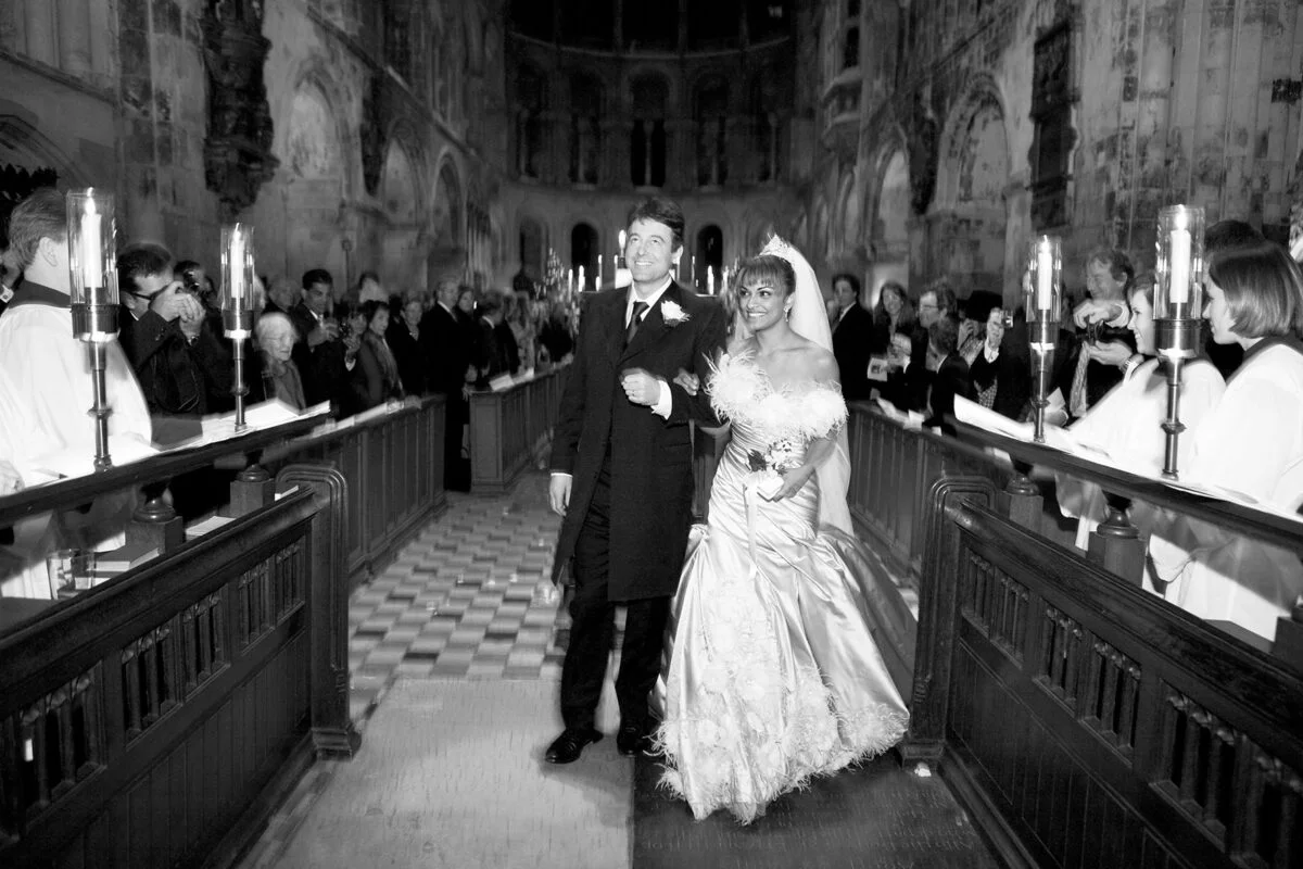 A bride and groom walking down the aisle of a church.