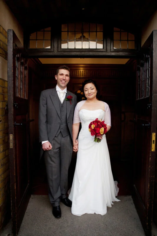 A bride and groom standing in front of a door.
