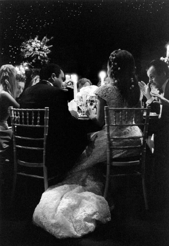 A black and white photo of a bride and groom sitting at a table.