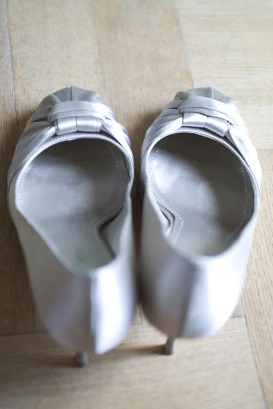 A pair of silver shoes on a wooden floor.