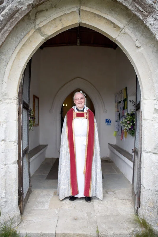 A priest standing in the doorway of a church.