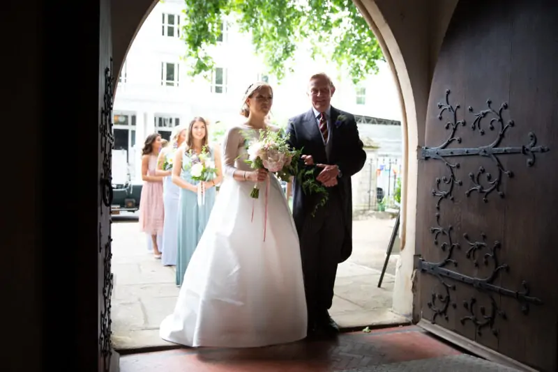 A bride and groom standing in a doorway.