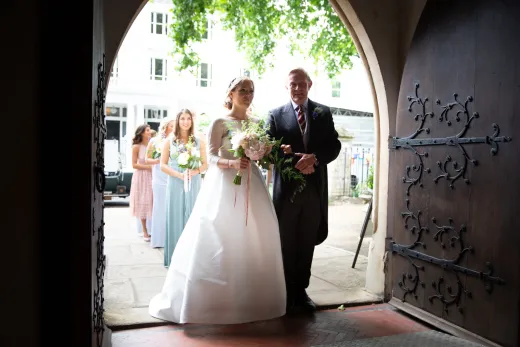 A bride and groom standing in a doorway.
