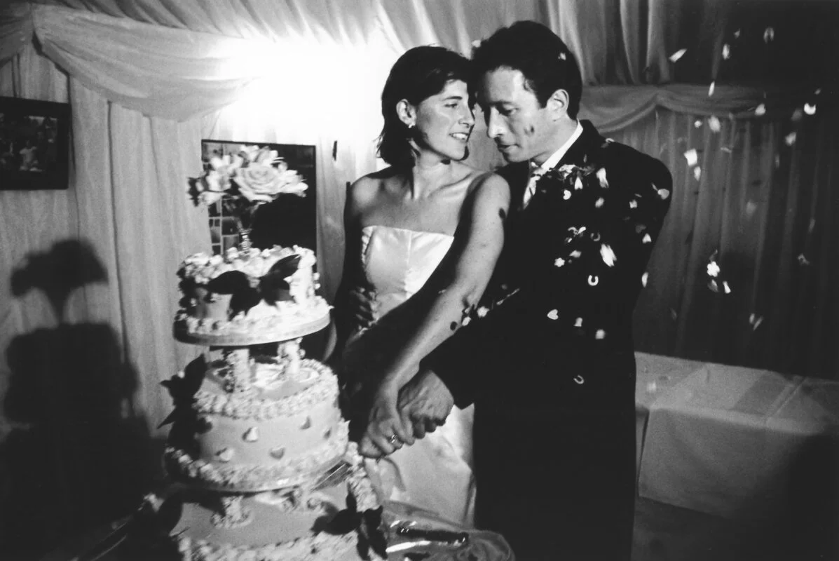A bride and groom cutting their wedding cake.