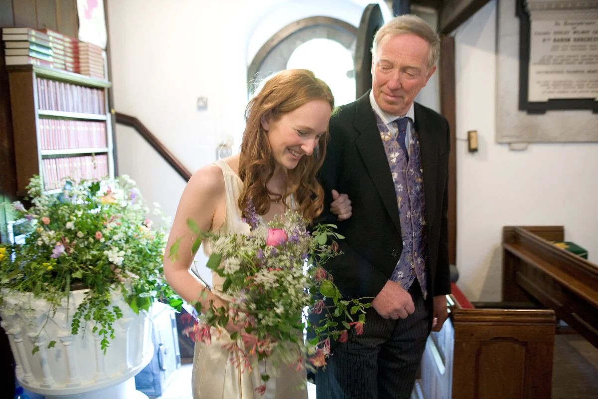 A bride walks down the aisle with her father.
