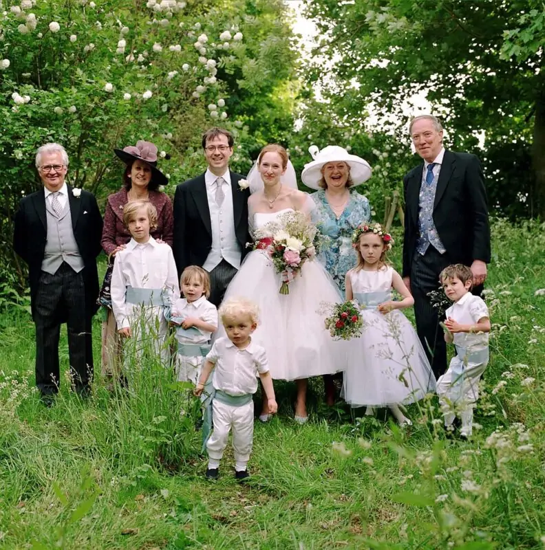 A wedding party posing for a photo in a field.