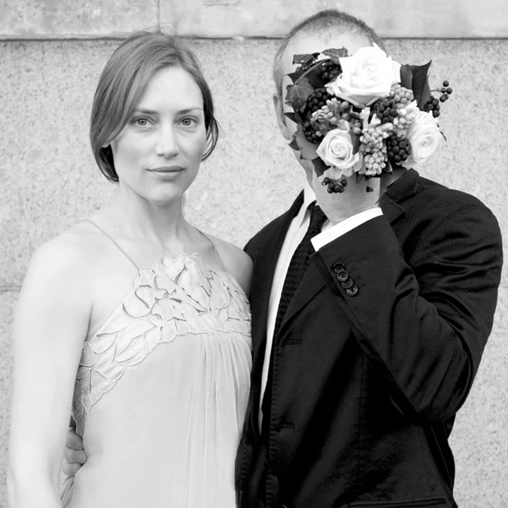 A man and a woman holding a bouquet of flowers.