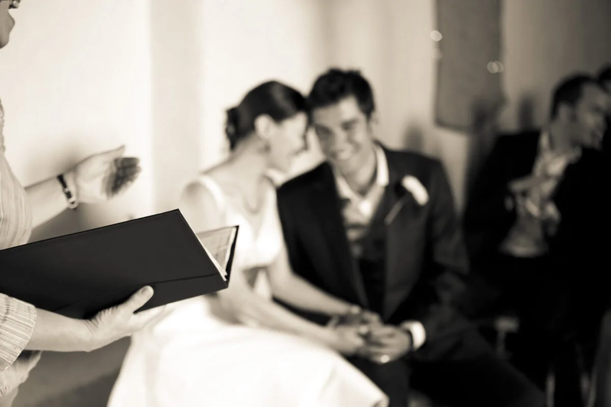 Black and white photo of a bride and groom at a wedding ceremony.