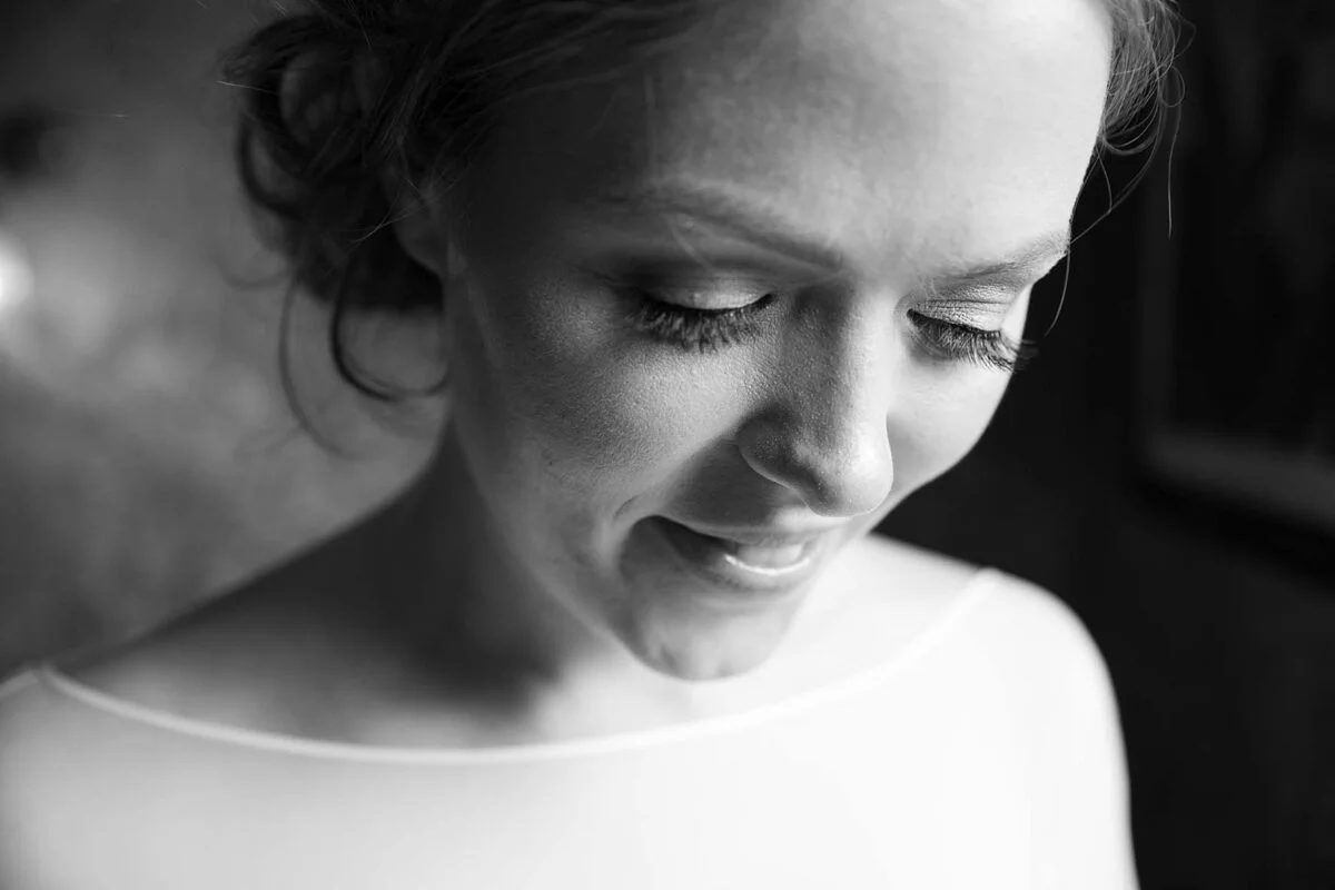 A black and white photo of a bride with her eyes closed.