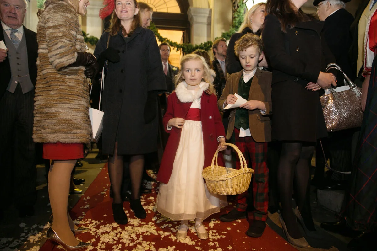 A little girl standing on a red carpet.