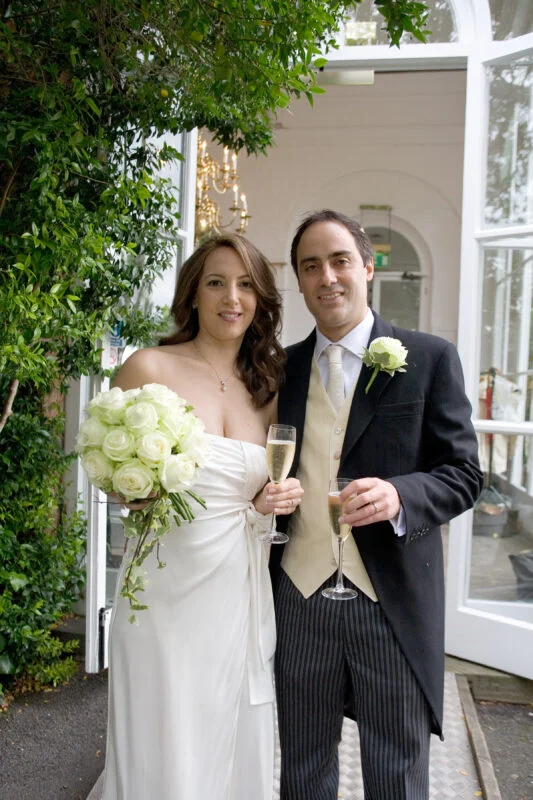 A fine art wedding photographer captures a man and a woman in London, dressed in wedding attire.