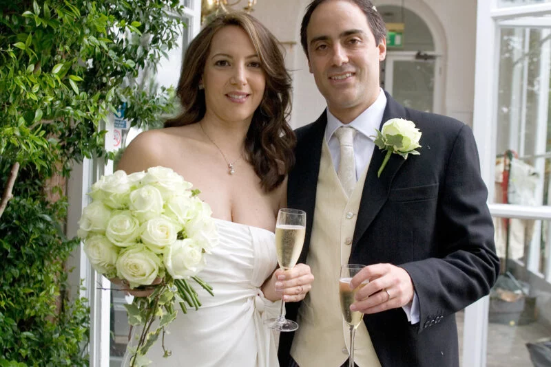 A fine art wedding photographer captures a man and a woman in London, dressed in wedding attire.
