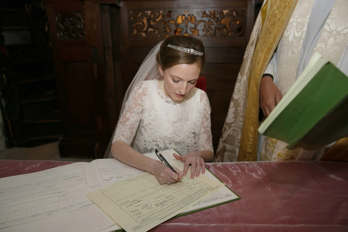 A bride signing a wedding certificate in a church.