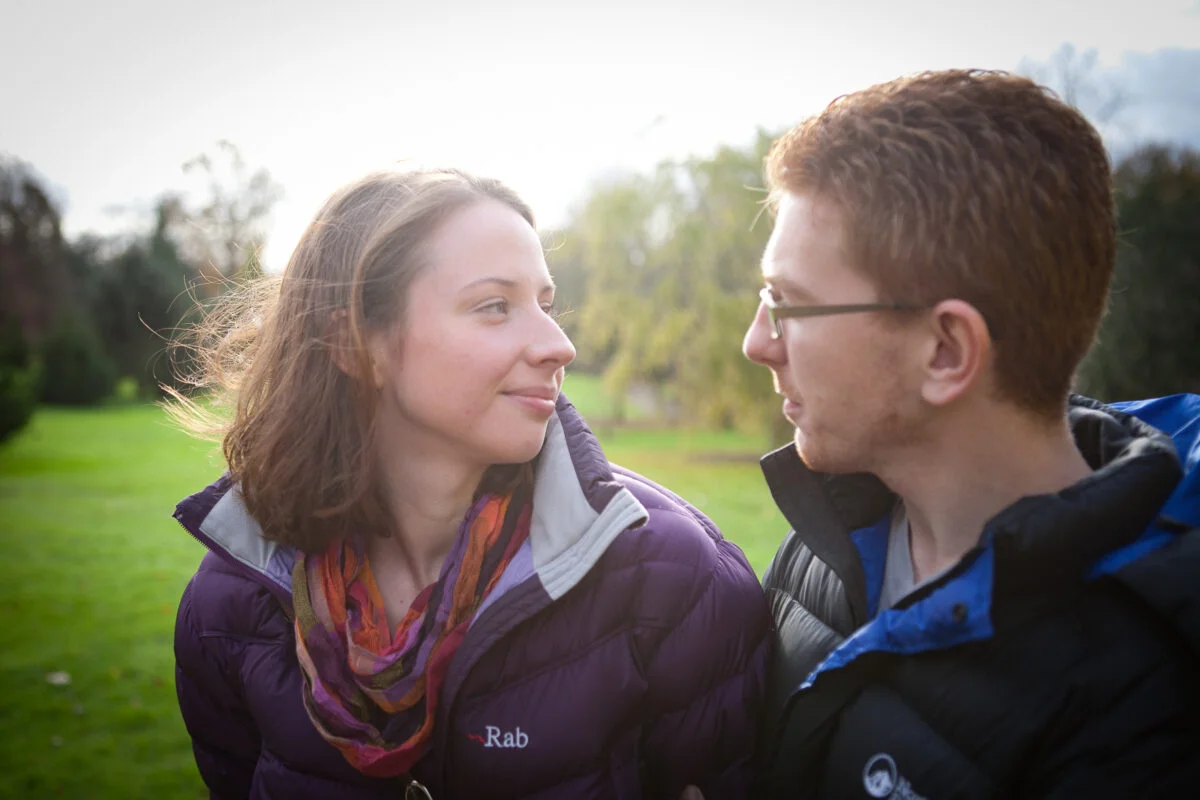 A man and woman looking at each other in a park.