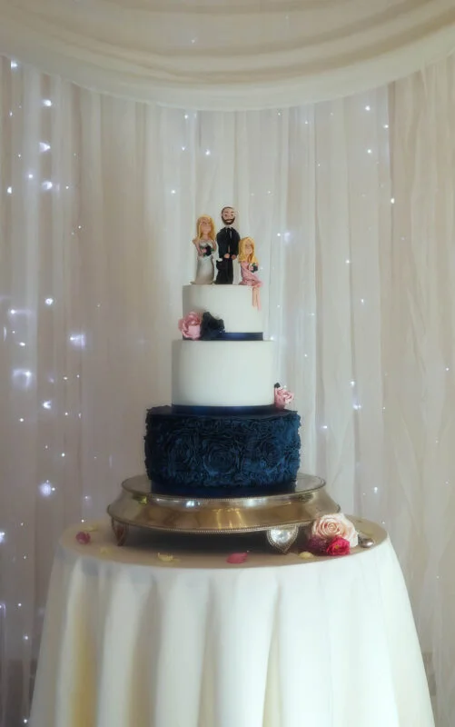 A wedding cake with a couple on top.