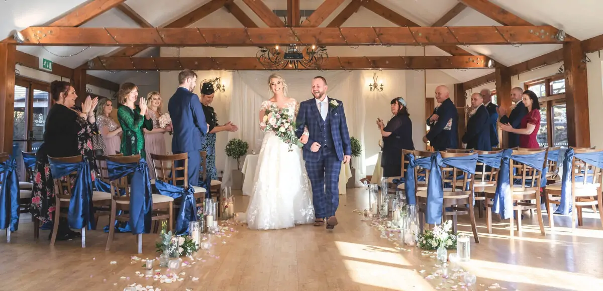A bride and groom walking down the aisle at their wedding.