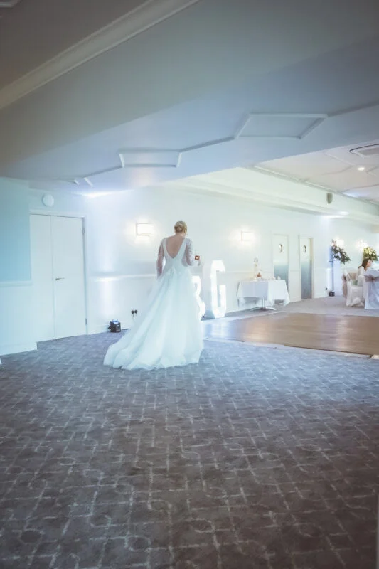 A bride walking down the aisle at a wedding reception.