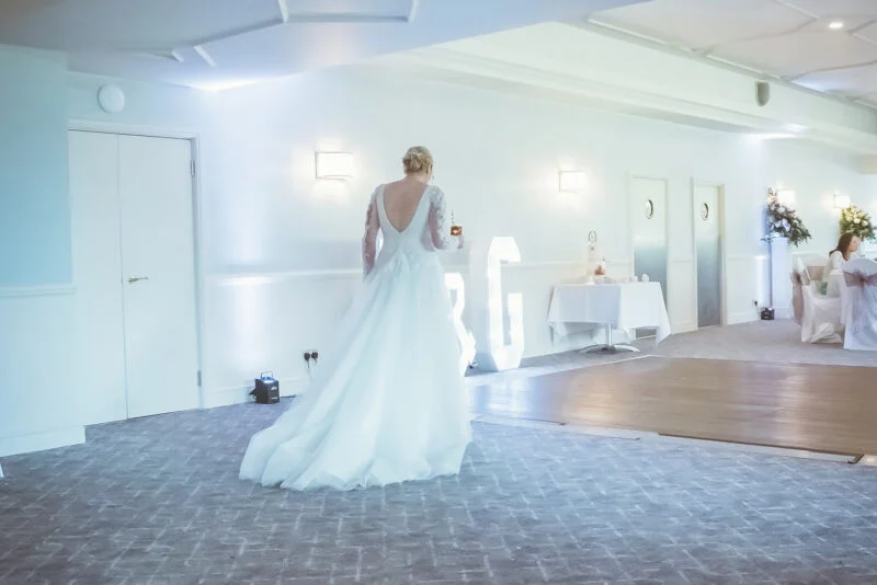 A bride walking down the aisle at a wedding reception.