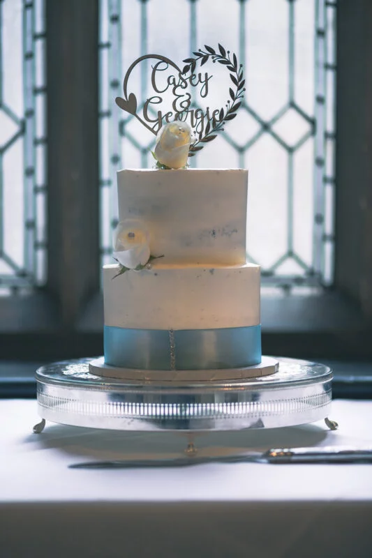 A cake on a table in front of a window.