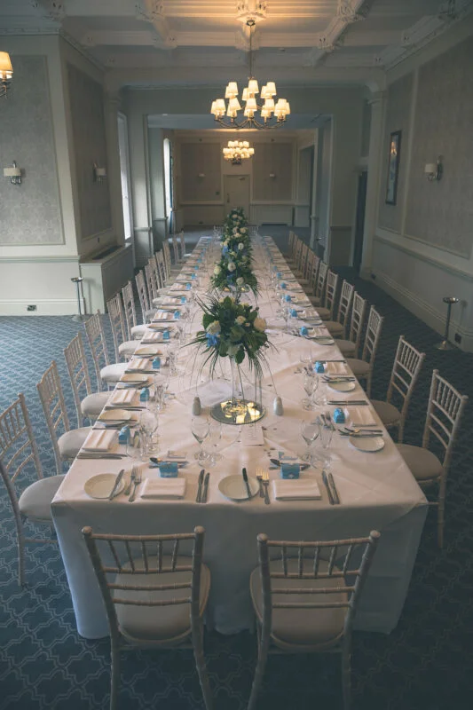 A table set up for a wedding reception in a large room.