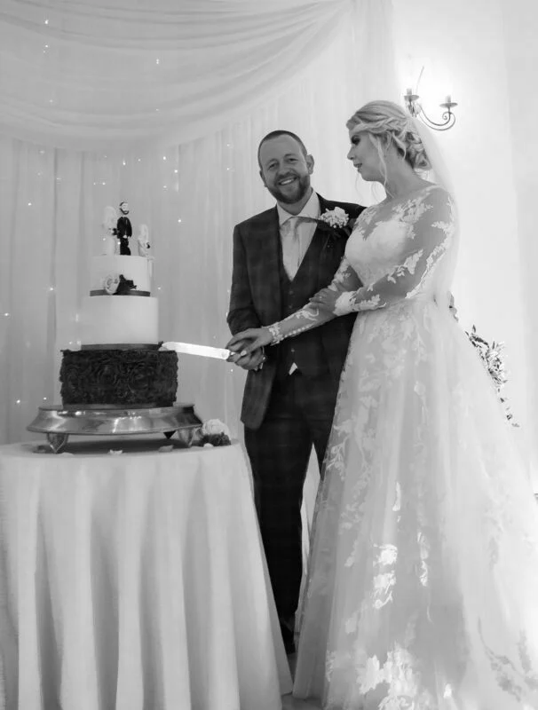 A bride and groom cutting their wedding cake.