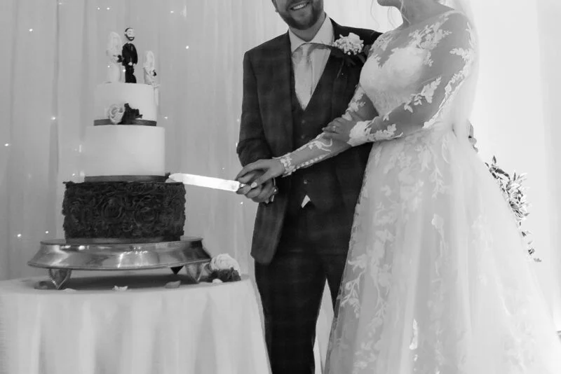 A bride and groom cutting their wedding cake.