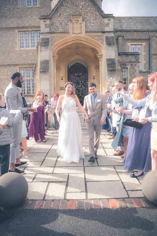 A bride and groom walking down the steps of a large building.