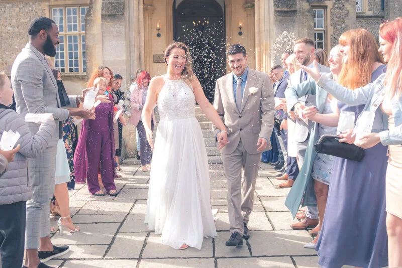 A bride and groom walking down the steps of a large building.