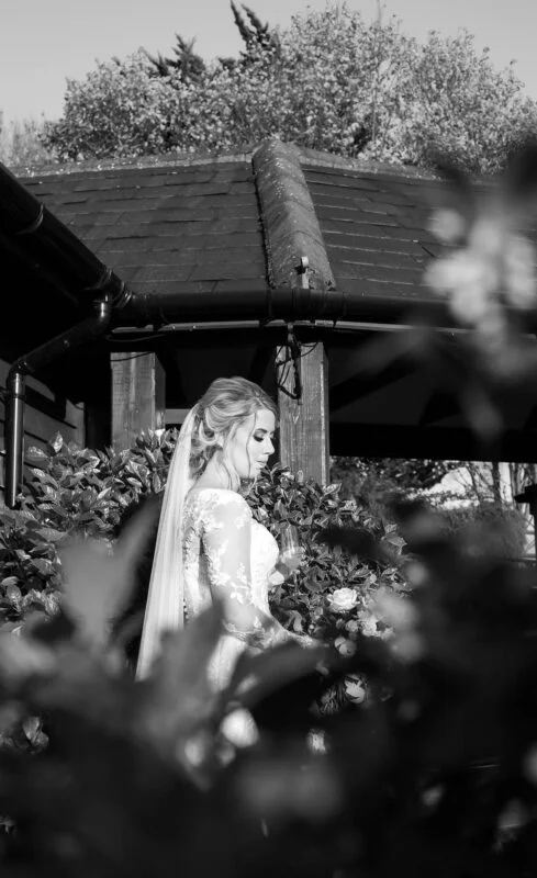 A bride and groom standing in front of a gazebo.