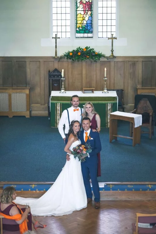 A bride and groom posing for a photo in a church.