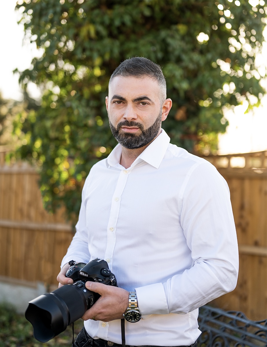 East London wedding photographer capturing moments in front of a fence.