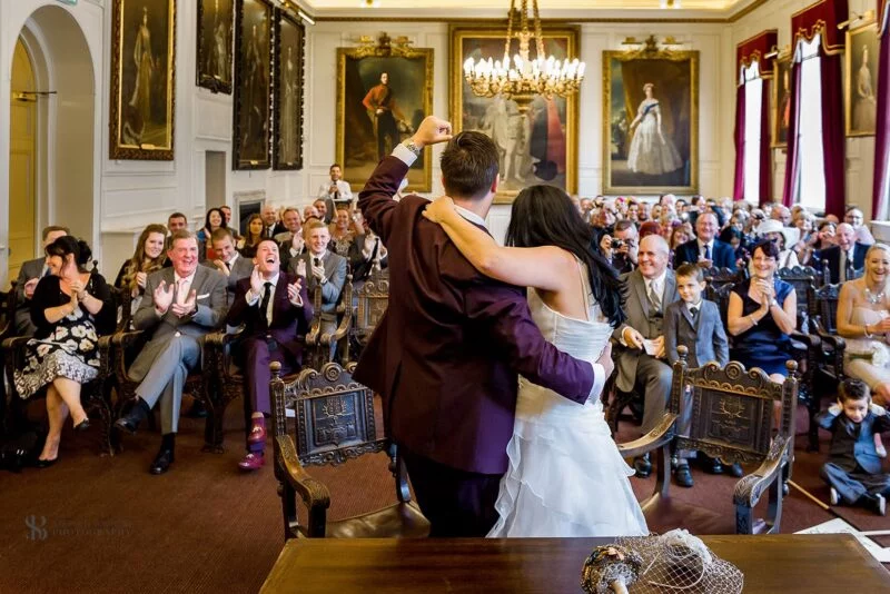 A bride and groom sharing their first dance in a large room.
