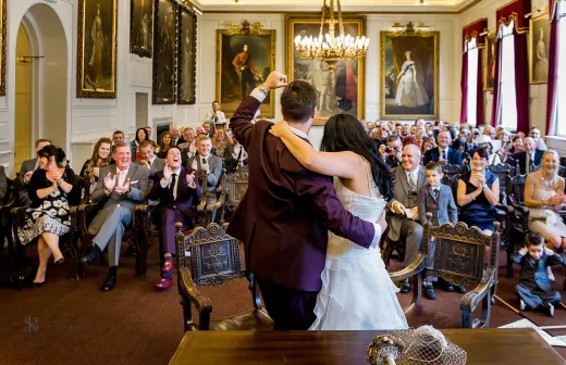 A bride and groom sharing their first dance in a large room.