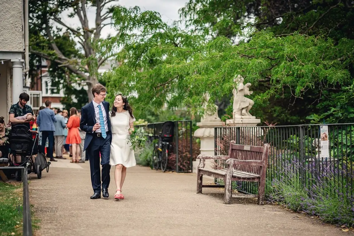 A bride and groom walking down a path.