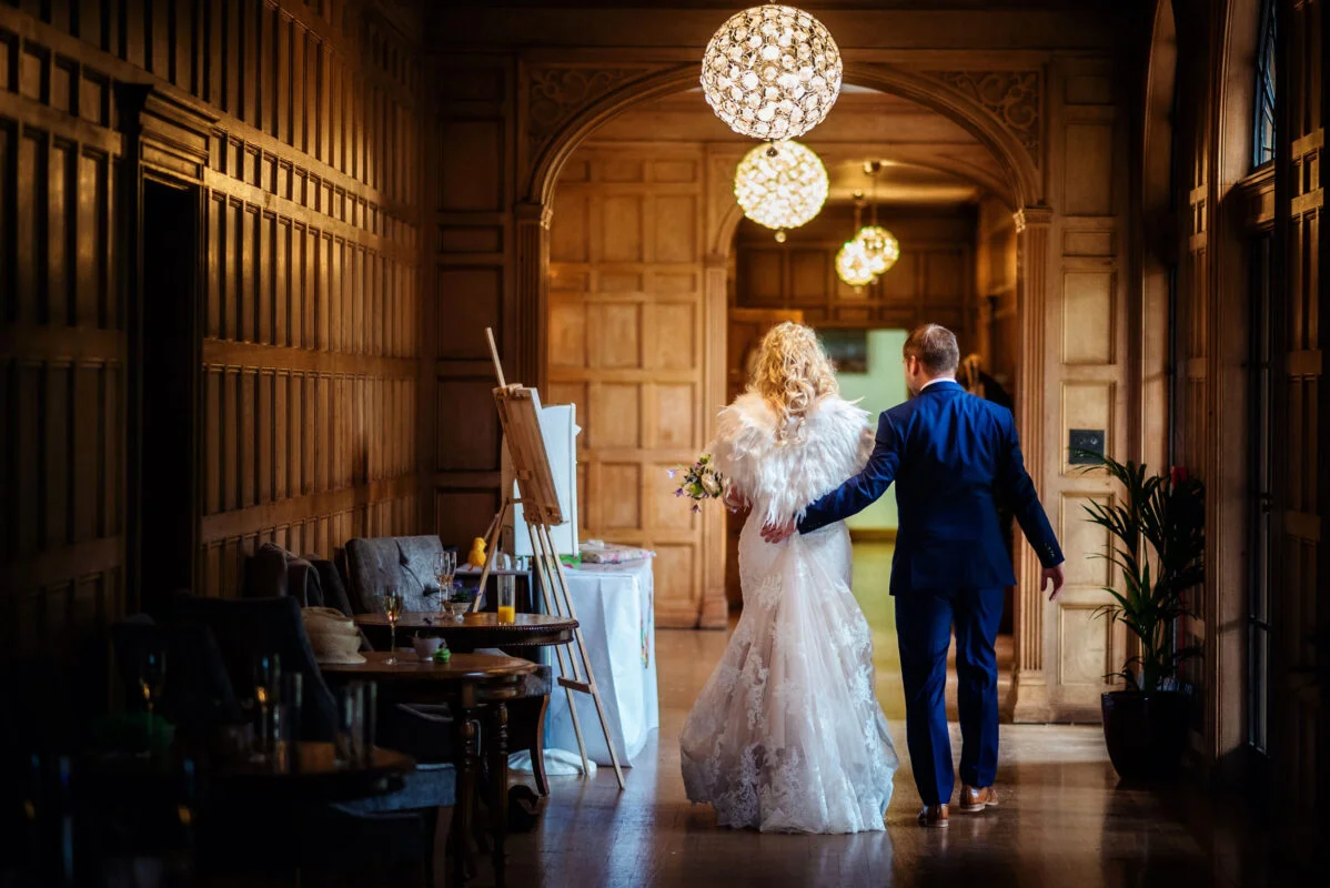 A bride and groom walking down a hallway.