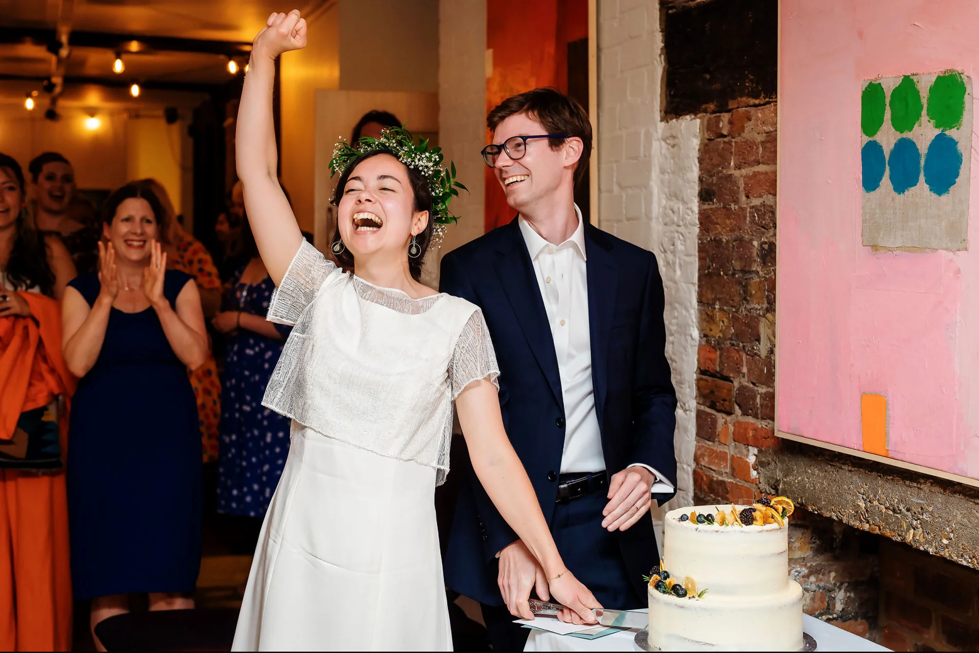 A couple cutting their wedding cake at a cheap wedding in London. (listing)