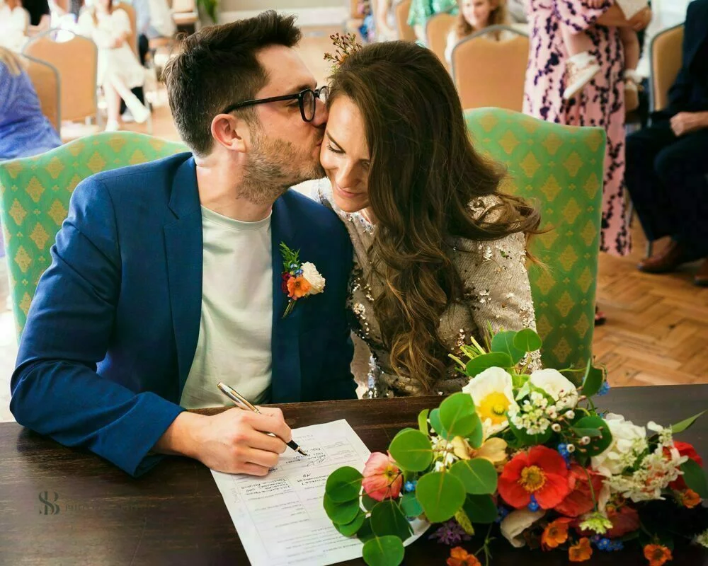 A bride and groom kissing at a wedding ceremony.