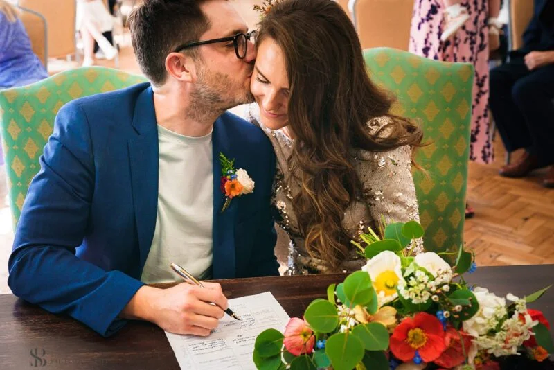 A bride and groom kissing at a wedding ceremony.