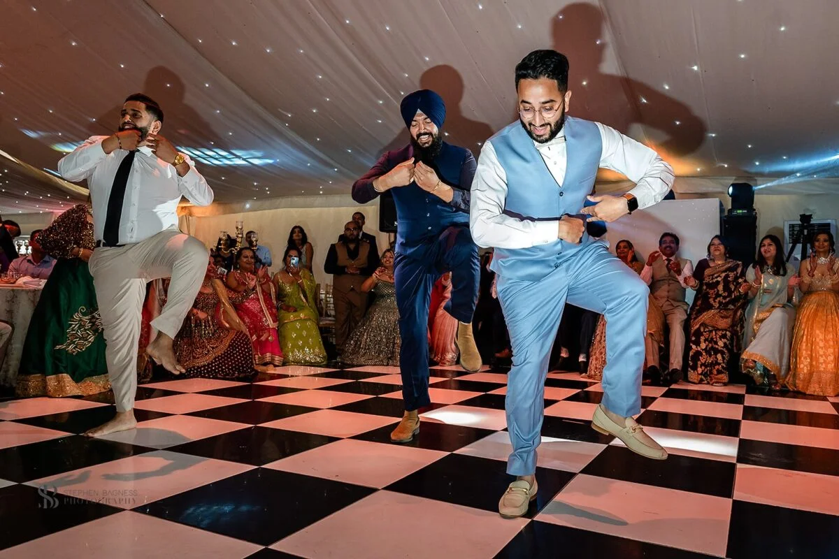 A group of men dancing on a checkered floor.