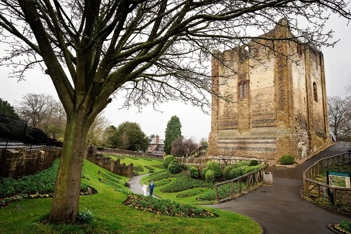 A large stone tower with a garden in front of it.