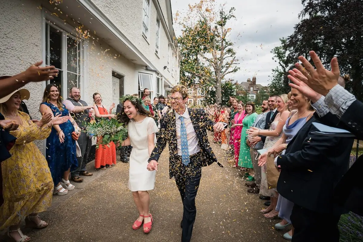 A bride and groom are surrounded by confetti at their wedding.