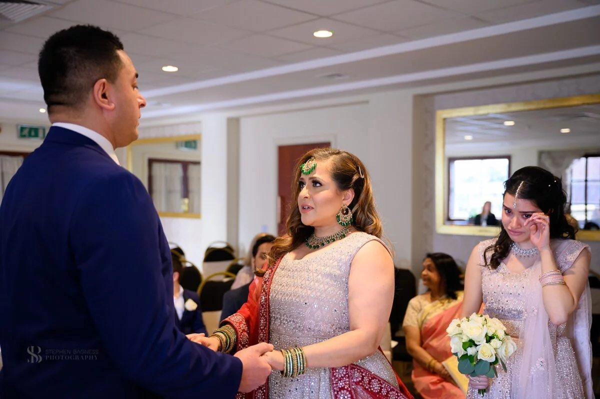 A bride and groom exchange rings at a wedding ceremony.
