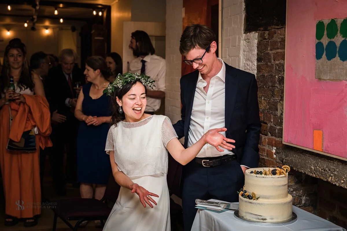 A bride and groom cutting their wedding cake.