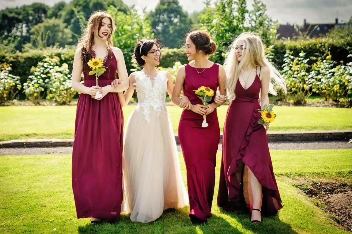 Four bridesmaids in burgundy dresses.