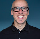 A West London wedding photographer capturing a bald man with glasses smiling for the camera.