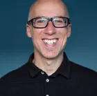 A West London wedding photographer capturing a bald man with glasses smiling for the camera.
